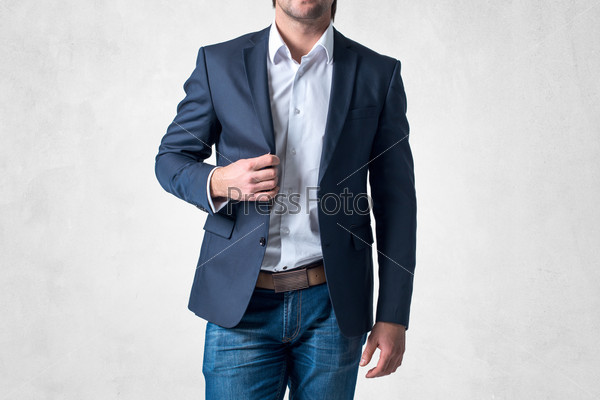 Man in trendy suit standing alone holding his jacket with confidence