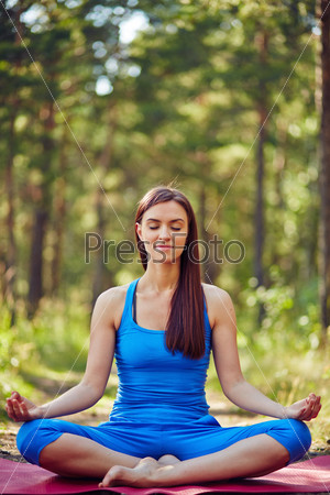 Meditating woman in sportswear enjoying outdoor yoga