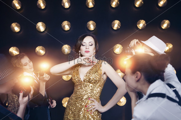 Superstar woman wearing golden shining dress posing to paparazzi