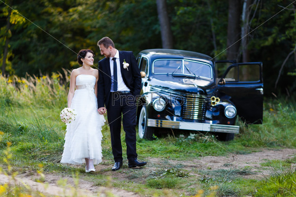 A wedding couple with old car