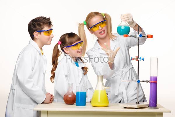 Teens and teacher of chemistry at lesson making experiments