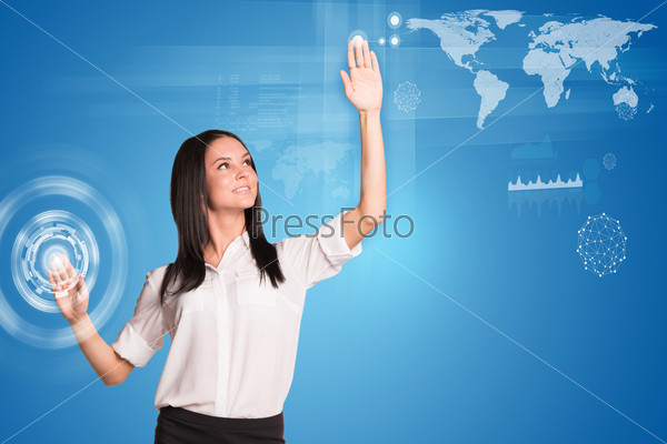 Young woman pressing button and looking up at left hand social network future interface, pressing light point on holographic screen. Social network concept, stock photo