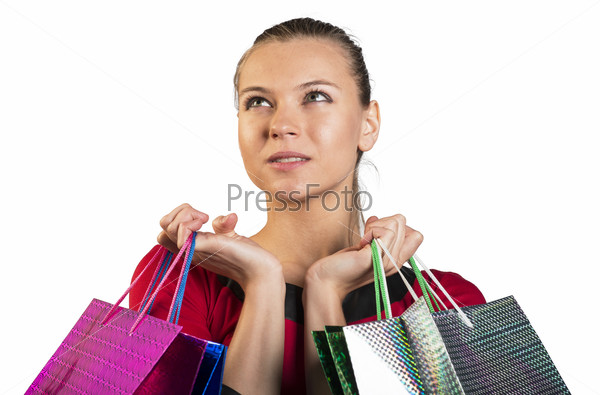 Sad young lady handing colorful shopping bags, narrowing her eyes and looking upper left corner. Closed up. Isolated background