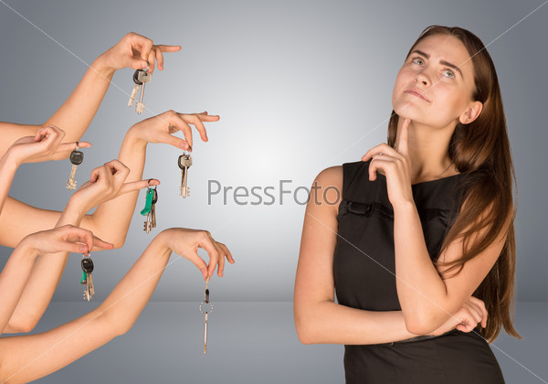 Business woman with  thoughtful face and several hands offering keys looking up. Isolated grey background