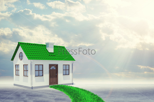 Small house with green roof and grass path on abstract grey sky background, stock photo