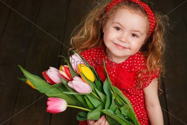 Cute little girl holding tulip bouquet. Studio portrait. Girl with tulips. Mother\'s Day, March 8, International Women\'s Day.