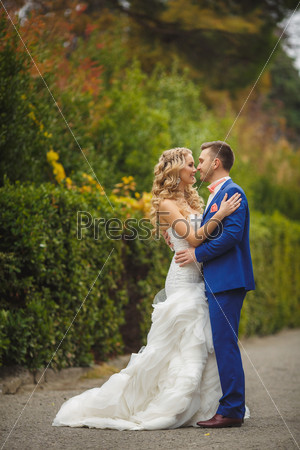 Wedding, Beautiful Romantic Bride and Groom Kissing and Embracing outdoors in nature. wedding kiss. Young newly married couple posing. Together