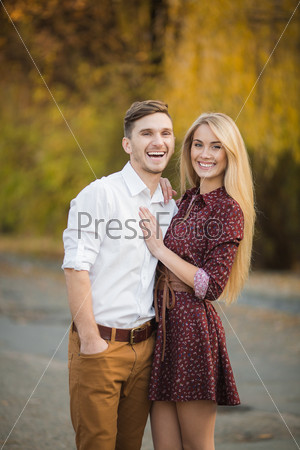 Cheerful couple having fun on summer vacation. Portrait of a happy couple laughing at camera. Young couple in the countryside in autumn.