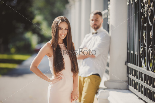 Couple in love kissing laughing having fun. Dating interracial young couple embracing on date. Pretty summer sunny outdoor portrait of young stylish couple while kissing on the street. Relationships