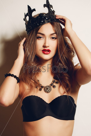 sexy woman in black crown. Beautiful young woman posing with a crown on her head. Emotional woman portrait