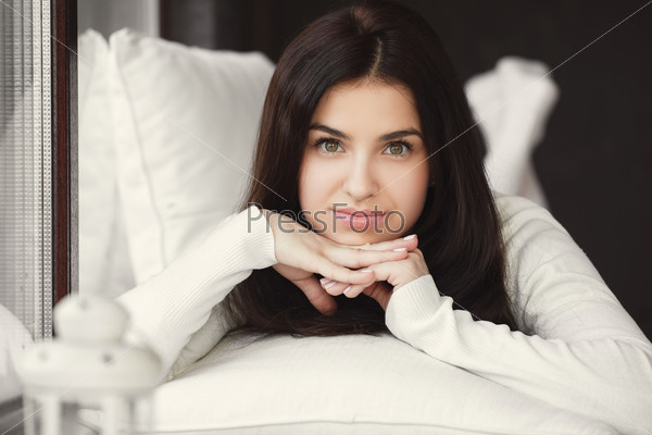 Woman lying in bed smiling. lady laying in bedroom at early morning. Woman lying in bedroom smiling near window.