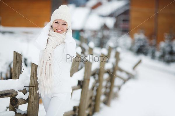 Beautiful winter portrait of young woman in the winter snowy scenery. Young woman winter portrait. Shallow dof. Snow winter woman portrait outdoors on snowy white winter day.