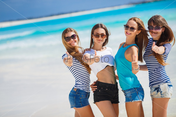 summer, holidays, vacation, happy people concept - beautiful teenage girls or young women showing thumbs up. Ocean view, group of women on the beach.
