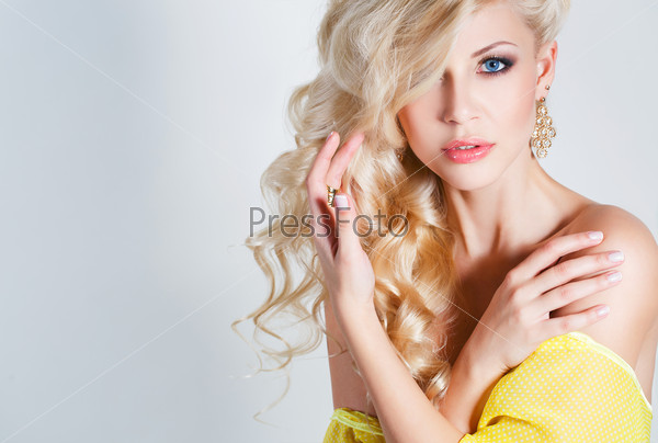 Beautiful blond woman with long curly hair - isolated on white. Portrait of young beautiful woman with long blond hair. Pretty woman in beautiful sexy yellow dress