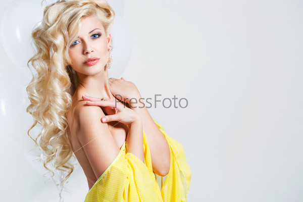 Beautiful blond woman with long curly hair - isolated on white. Portrait of young beautiful woman with long blond hair. Pretty woman in beautiful sexy yellow dress