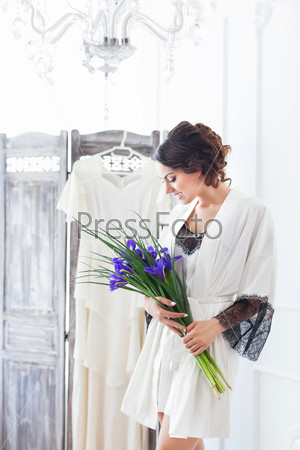 Beautiful young bride with a wedding bouquet. Last preparations for the wedding. Bride waits for her groom. Morning, the bride. Details