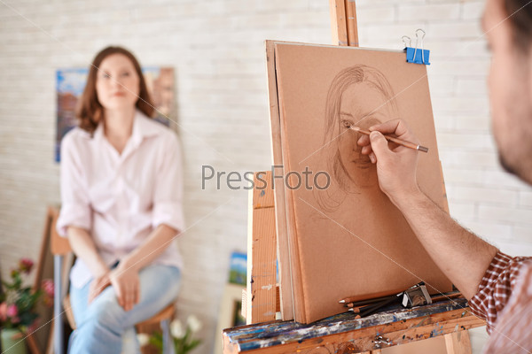Hand of male artist drawing his muse