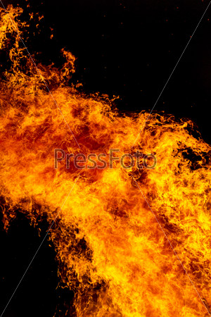 Burning campfire at night, combs flame as texture and background, strong branches burning trees of a forest fire