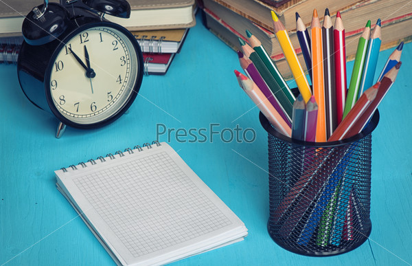 school supplies and notepad for copy space on a blue desk