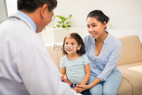 Doctor explaining prescription to little girl and her mom