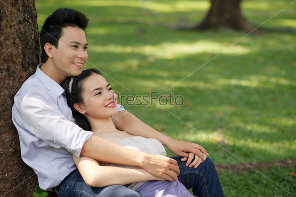 Serene Vietnamese couple in love resting in the park