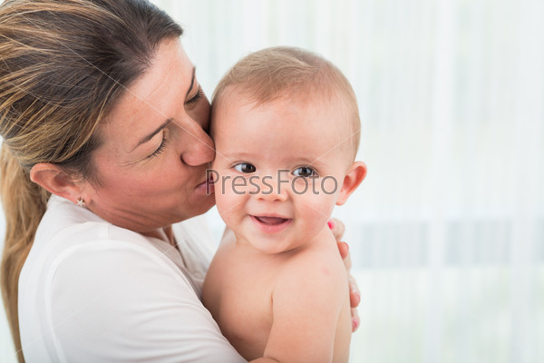 Close-up image of mother kissing her infant son