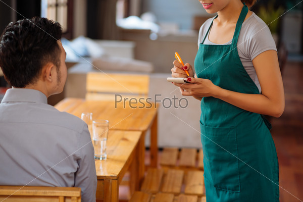 Waiter taking order from her customer in a restaurant