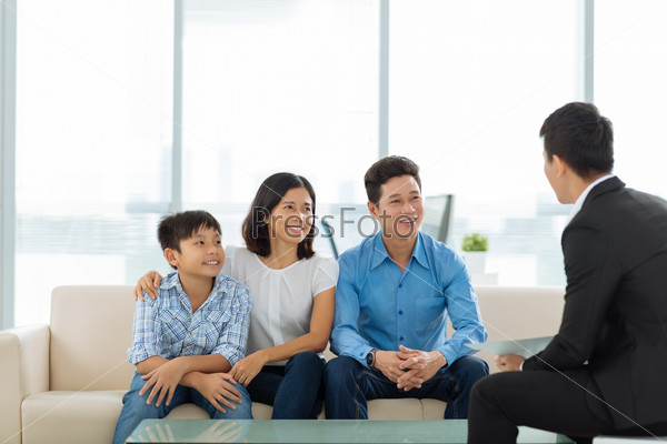 Happy Vietnamese family of three at the meeting with real estate broker