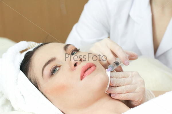 Woman Having Botox Treatment At Beauty Clinic, close up. Focus on syringe