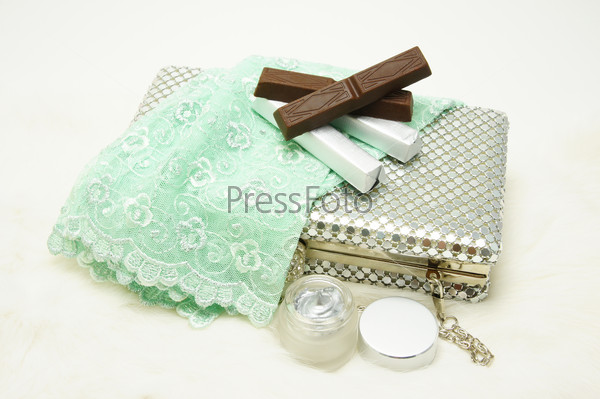 Evening bag with lace gloves, chocolate and cosmetic.