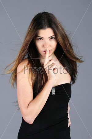 Beautiful oriental woman lifted a finger to her mouth