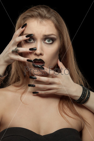 Gothic woman with hands of vampire on her face. Halloween