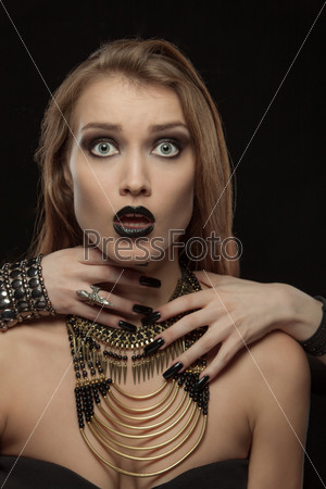 Portrait of a gothic woman with hands of vampire on her neck on black background. Halloween