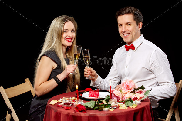 Portrait Of Romantic Couple Toasting white Wine At Dinner  on black background