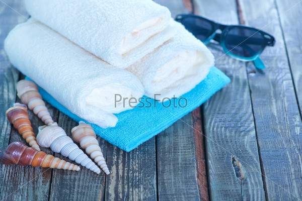 Black sunglasses with shells and white towel