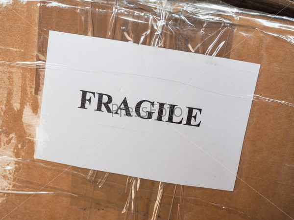 Fragile warning label tag on a cardboard box packet parcel for mail post shipping