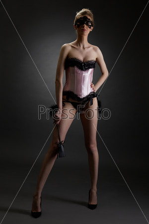 Domineering woman in erotic lingerie with lash