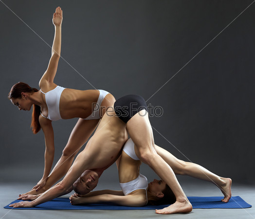 Yoga. Flexible people posing in difficult asanas