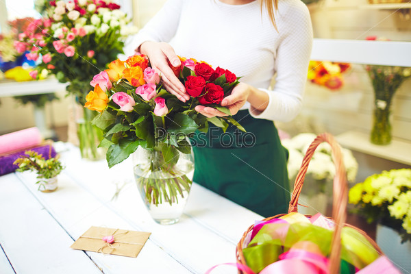 Female florist selecting fresh roses for bouquet