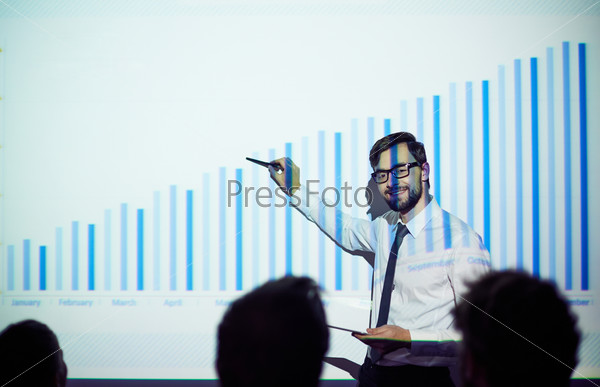 Confident male teacher presenting chart of finances to students or business people