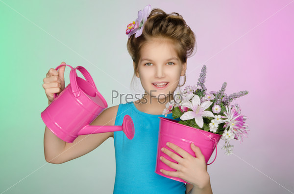 Happy girl with watering can and flowers