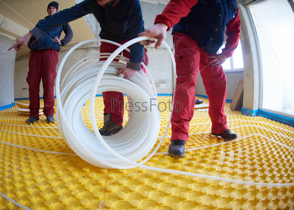 workers installing underfloor heating system