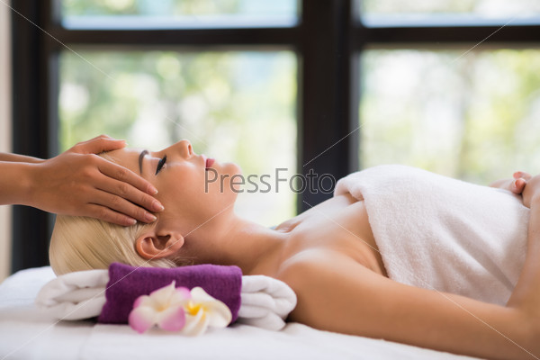 Woman getting professional head massage at spa resort