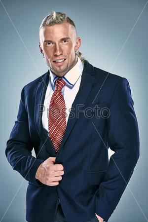 Portrait of an attractive young businessman wearing black suit. Blonde hair