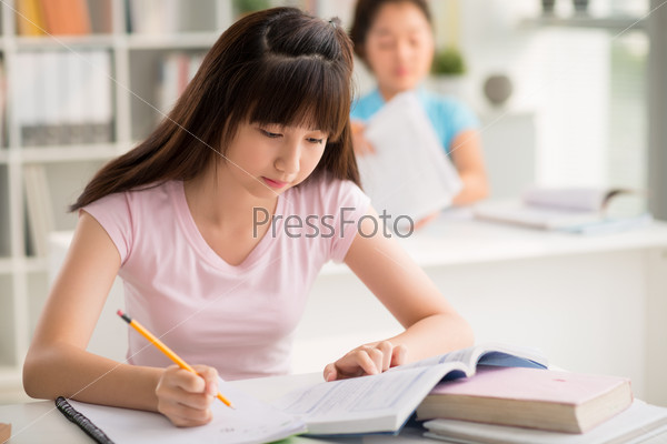 Vietnamese girl studying at desk in classroom