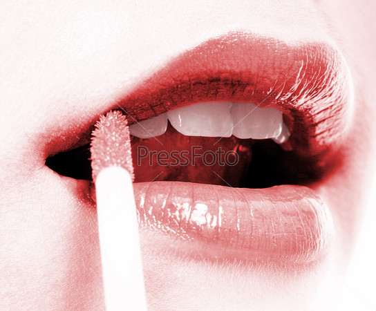Girl Applying Red Lip Gloss To Her Beautiful Lips