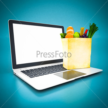 Paper bag with food and white laptop on a blue background