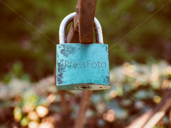 Vintage looking Love lock padlock sweethearts locked to a fence to symbolize eternal love
