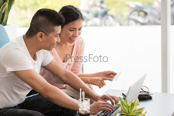 Couple entering information from the credit card to shop online