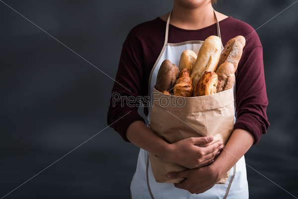Cropped image of woman holding grocery bag full of fresh bread